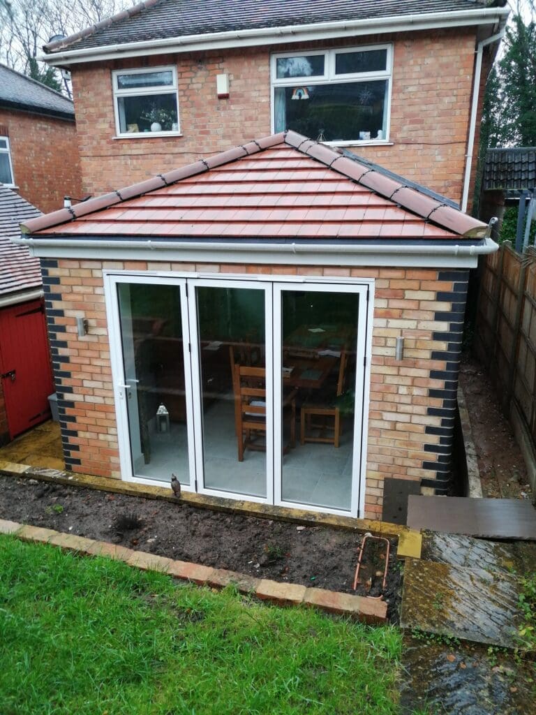 Completed single-storey rear extension with a hipped roof and glazed doors in Carlton, Nottingham